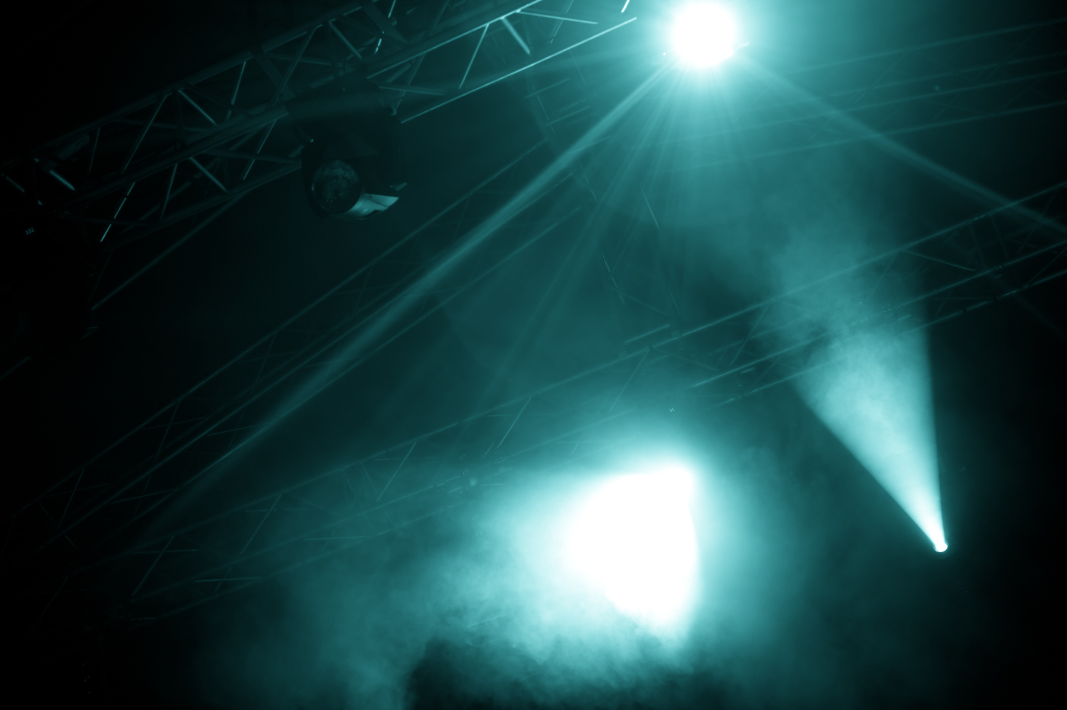 A view of foggy stage lights emerging from the dark